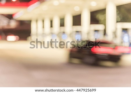 Blurred of gas station at night. Defocused, out of focus gas station and convenience store in evening. Abstract blur petrol station background with copy space. Vintage filter look.