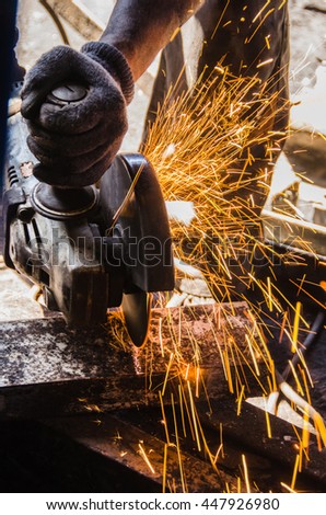 The picture shows a man cuts a steel beam.