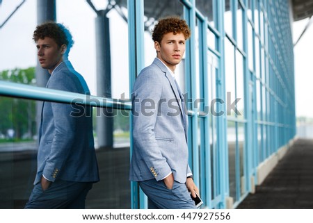Picture of handsome young confident redhaired businessman in the street