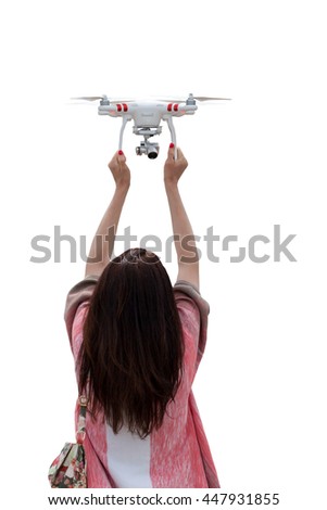 A woman is standing back, holding above her head a drone, making selfie. Isolated on white background