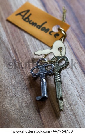 concept for a happy abundant life using old decorative keys and a hand written tag attached by a golden cord