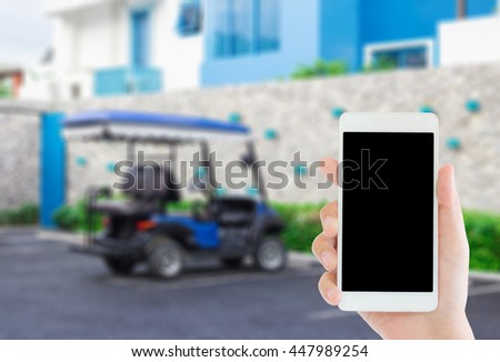 woman use mobile phone and blurred image of blue golf cart park in the car park near blue hotel