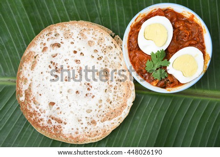 Vella appam/Palappam/Kallappam/ plain hoppers, a popular traditional Kerala breakfast bread with hot and spicy egg roast curry on a banana leaf, Alappuzha, India. South Indian food.