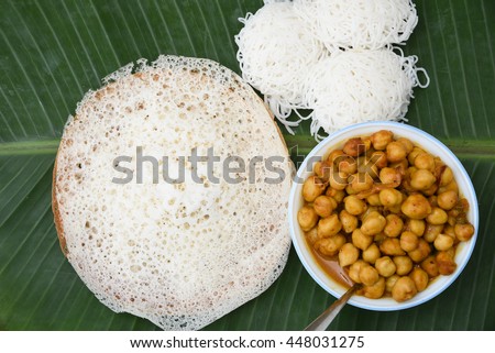 Vella appam/Palappam/Kallappam/plain hoppers and noolappam/Idiyappam/rice noodles, popular traditional Kerala breakfast with hot and spicy chickpea/lentil curry, Alappuzha, India. South Indian food.