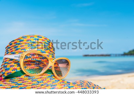 sunglasses and straw hat with blur blue sea and sky background, summer vacation time concept