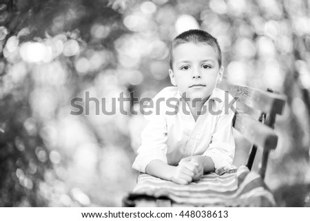 little boy lying on a park bench