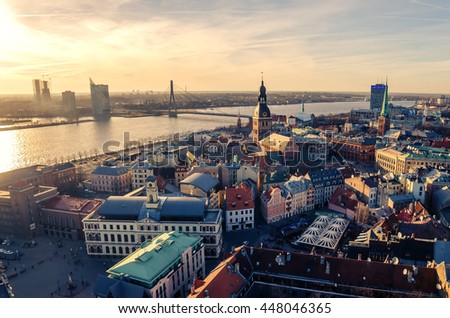 Riga, Latvia: aerial panoramic top view of Old Town and Daugava River at sunset. The tower of Dome Cathedral, a symbol of the Latvian capital city.