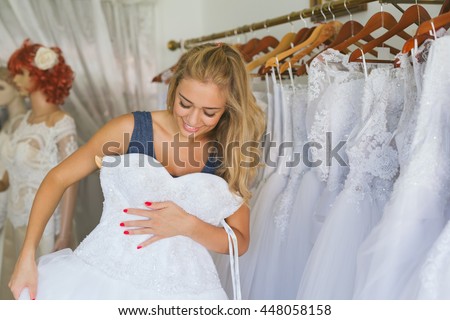 Woman choosing wedding dress in shop Royalty-Free Stock Photo #448058158