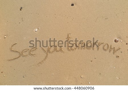 written words "See you tomorrow" on sand of beach
