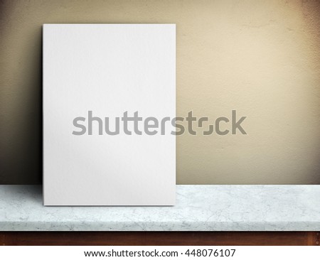 Blank White paper poster on marble table at yellow concrete wall,Template mock up for adding your design and leave space beside frame for adding more text.