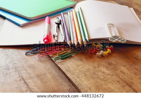 Back to school concept. Writing supplies on wooden desk. Filtered image, selective focus