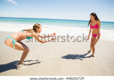 Young female friends playing on beach