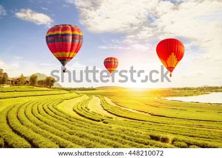 Hot air balloon at sunset time and green field, vintage and retro filter effect style