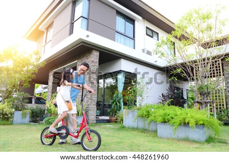 Healthy father and daughter playing together outside their new house. Home fun  lifestyle, family concept. Royalty-Free Stock Photo #448261960