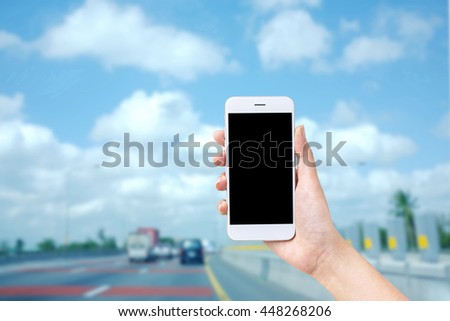 hand holding smartphone Blank screen on background is traffic.