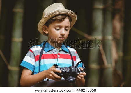 Young boy checking a photograph in camera at forest