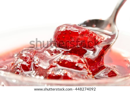Strawberry jam is stirred with a spoon on a white background. Fruit dessert close up. Confectionery. Royalty-Free Stock Photo #448274092
