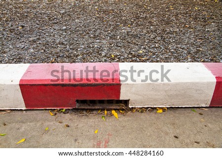 Red and White sign on the sidewalk background.