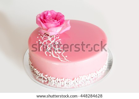 French mousse cake with pink mirror glaze and decorated with pink rose