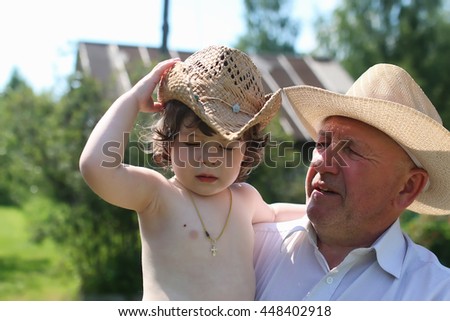 child and grandfather in cowboy hats