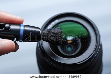 cleaning camera lens with lens pen brush                           