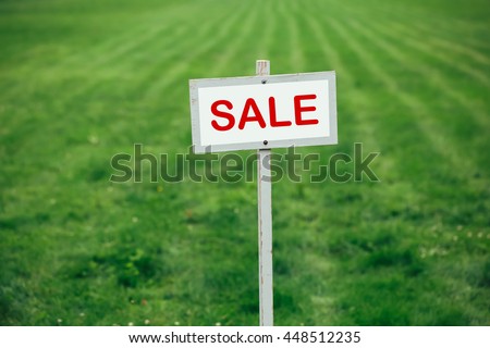 sale sign against trimmed lawn background