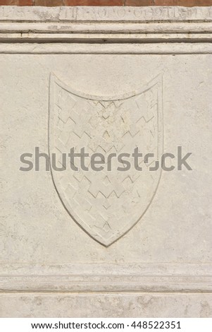 Relief of a medieval shield from an ancient sarcophagus on St John and Paul gothic facade, in Venice