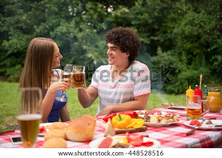 Happy couple making a toast. Outdoors in nature.