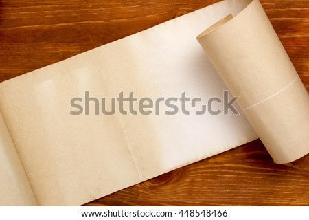 Old grunge paper scroll on a wooden background