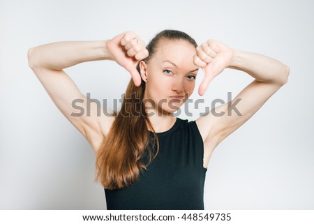 young business woman shows a sign of dislike, isolated on a gray background