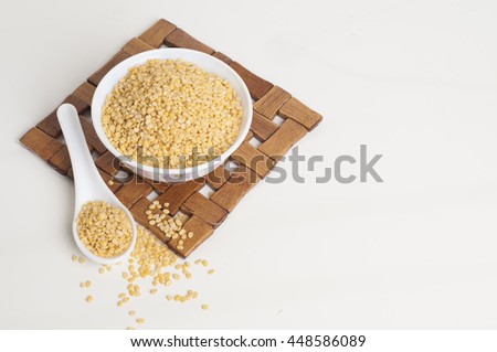 Moong dal in a bowl isolated on white background with spoon and table mat Royalty-Free Stock Photo #448586089