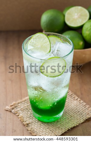 lime soda with green lemon on wooden background