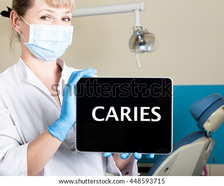 technology, internet and networking in medicine concept - femail dentist holding a tablet pc with caries sign. at the dental equipment background