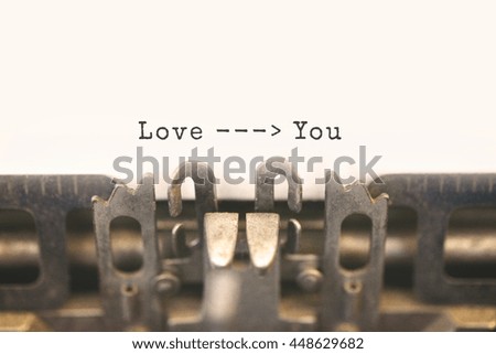 Close up of antique typewriter with text Love You on white paper. Selective focus on message, vintage filter style. 