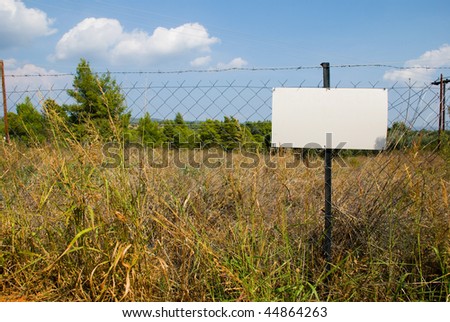 Blank white sign on a chain link fence.