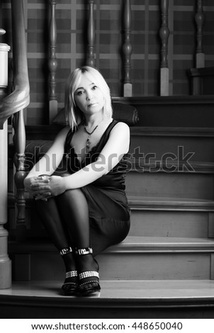 Beautiful woman sitting on the stairs and looking into the camera