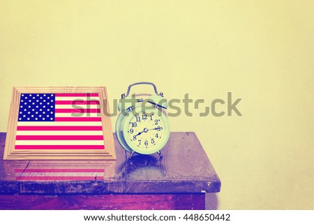 Alarm clock and USA photo frames on the wooden table - Vintage effect background