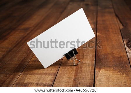 Photo of blank business card on vintage wood table background. Mock-up for ID. Blank template for branding identity for designers.