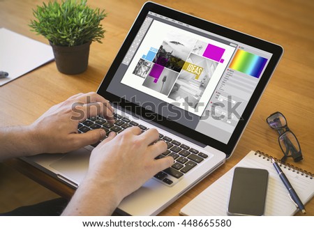graphic design concept. Close-up top view of a designer working on laptop. all screen graphics are made up.