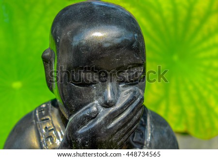 laughing Buddha with green leafs in the background - who said that - keeping secret
