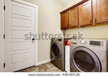  Laundry room with steel appliances and nice cabinets, tile floor and beige walls