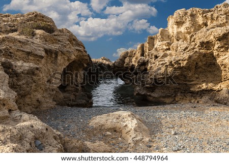 Sea bay - rocks in the sea water against  cloudy blue sky. Mediterranean coast. Cyprus