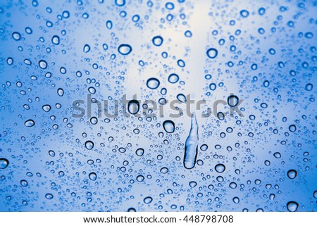 Water drops on glass with light blue background