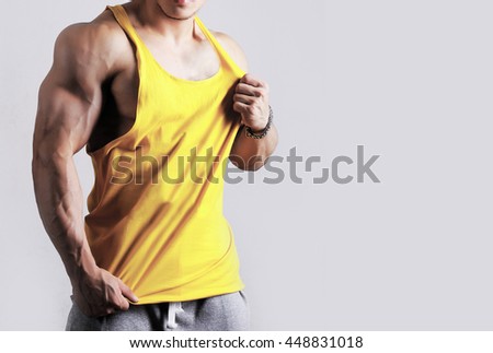 Close up photo of attractive bodybuilder wearing blank yellow sleeveless t-shirt, vest