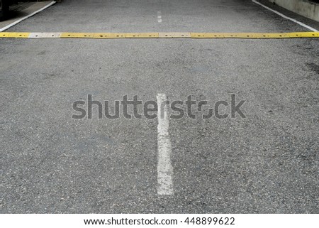 Yellow speed bump on asphalt road