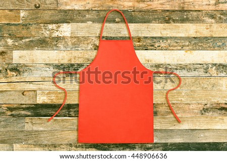 Top view of kitchen apron on vintage wooden background