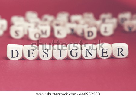Designer word written on wood cube with red background
