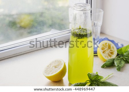 Citrus fizzy drink with basil in a bottle, summer cold drink