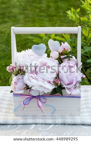 Floral arrangement with peonies in wooden box