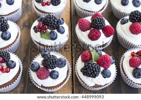 Cupcakes with Fruits on a Rustic Wooden Table.